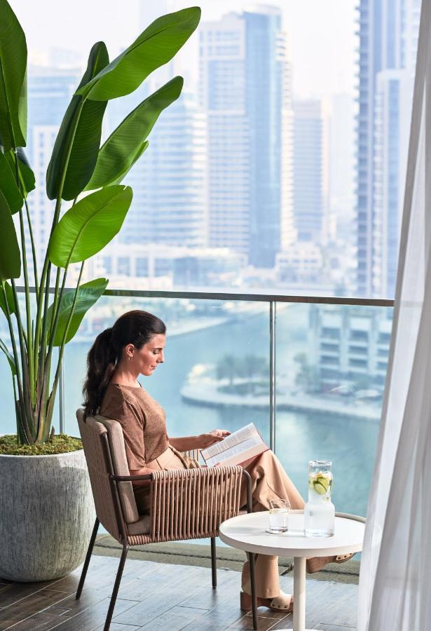 Jumeirah Living Marina Gate Dubai Aparthotel Exterior photo A woman reading on a balcony